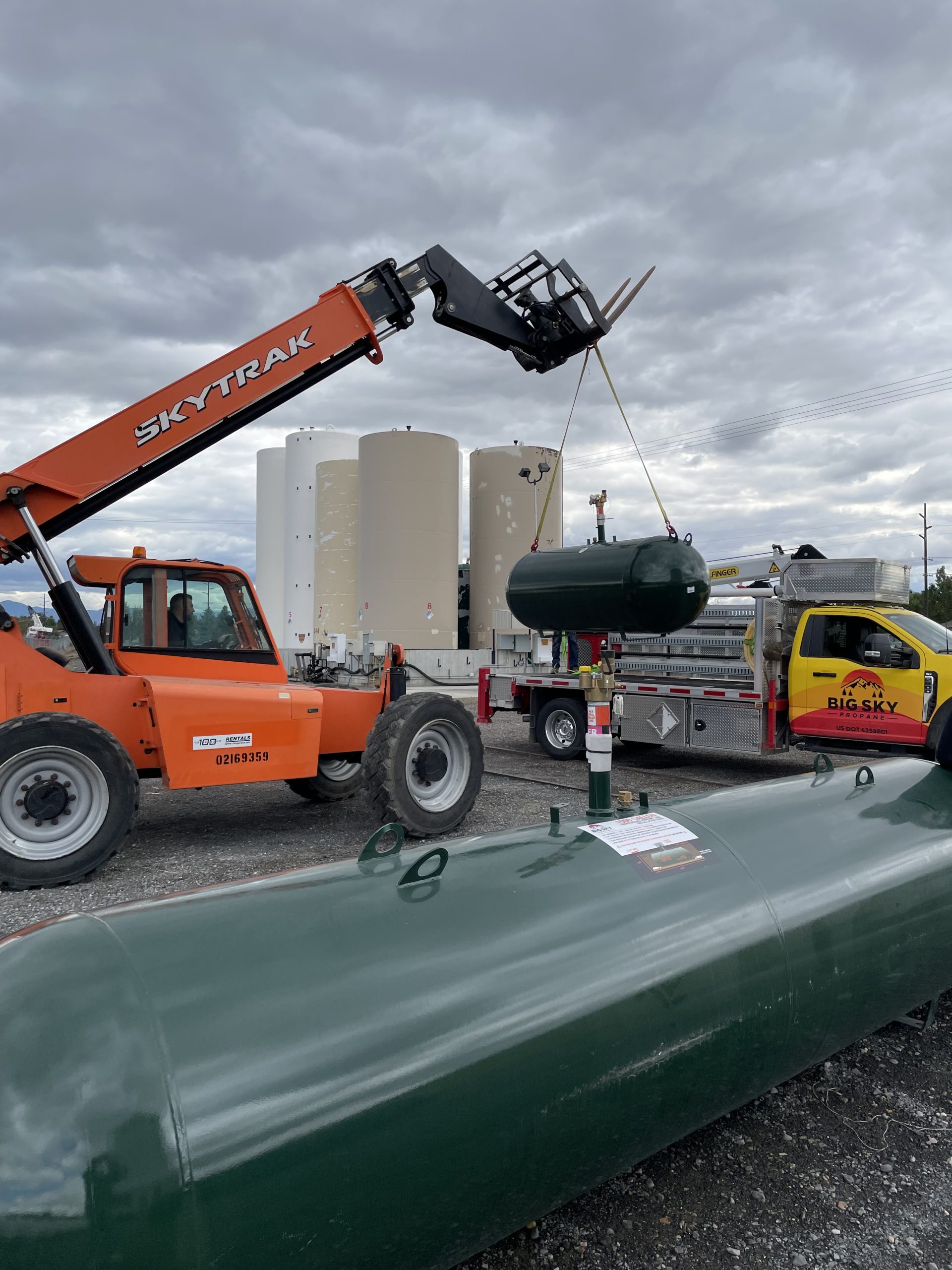 Green tank being loaded on truck